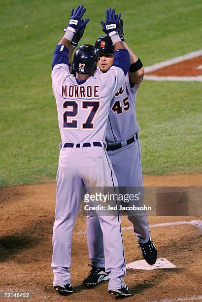Alexis Gomez is congratulated by Craig Monroe of the Detroit Tigers after hitting a two run home run during the sixth inning of Game Two of the...