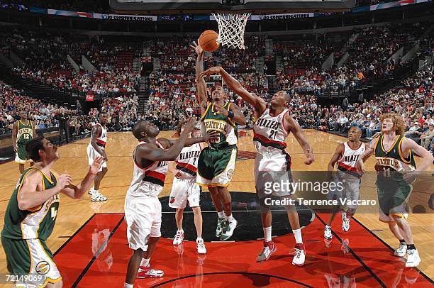 Earl Watson of the Seattle SuperSonics goes to the basket against Jamaal Magloire and Zach Randolph of the Portland Trail Blazers on October 11, 2006...