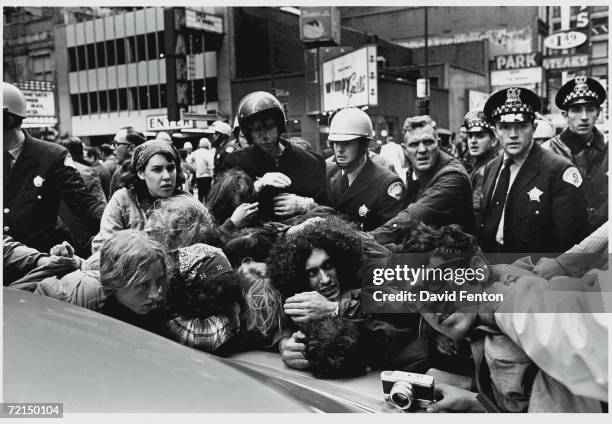 Group of young men and women are held against a car as they are detained and arrested by police at 'Days of Rage' protest activities, Chicago,...