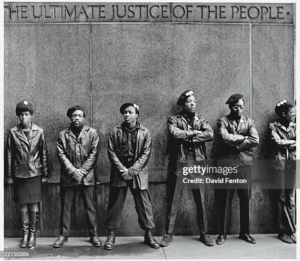 View of a line of Black Panther Party members as they demonstrate, arms folded, outside the New York County Criminal Court , New York, New York,...