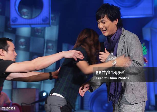 Taiwan singer Jeff Chang reacts as a fan tries to embrace him, during a fan club activity to promote his new album on October 11, 2006 in Nanjing of...