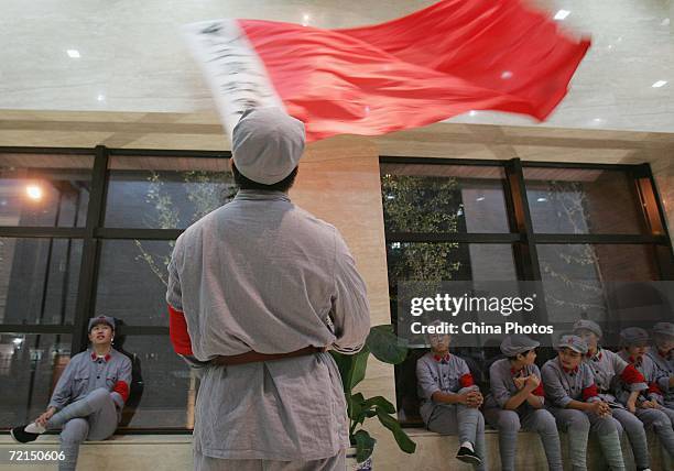 Undergraduate waves a flag of Red Army before to come on stage to dance during a ceremony to mark the 70th anniversary of victory of the Long March...
