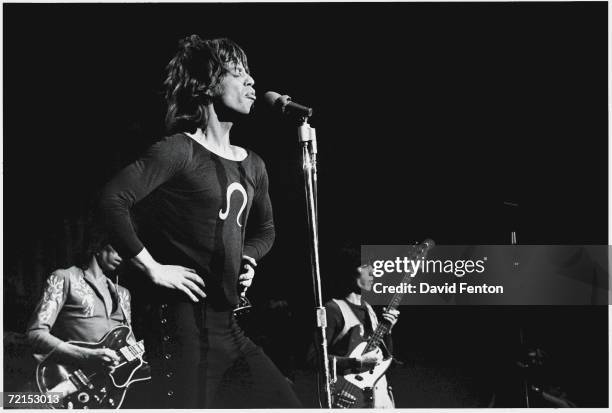 English singers, musicians, and songwriters Mick Jagger , Keith Richards and Bill Wyman of the rock band 'The Rolling Stones,' perform on stage at...