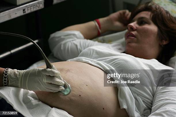 Kelli Freeman who is four months pregnant, lies on a bed as Zaditza Silveira uses an ultrasound machine to take images of her baby at the Birthing...