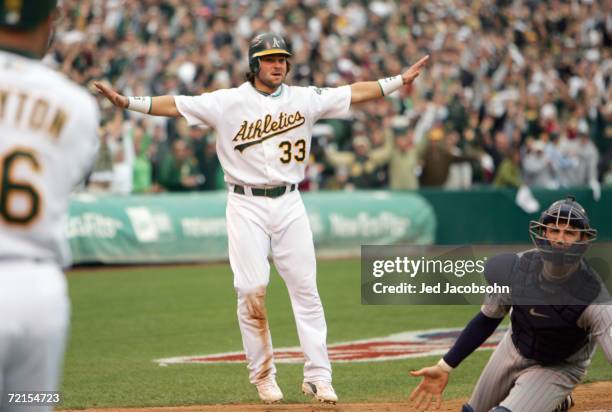 Nick Swisher the Oakland Athletics motions he is safe after sliding home against the Minnesota Twins to win game three of the American League...