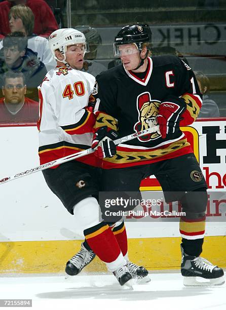 Alex Tanguay of the Calgary Flames runs into Daniel Alfredsson of the Ottawa Senators in a game on October 12, 2006 at the Scotiabank Place in...