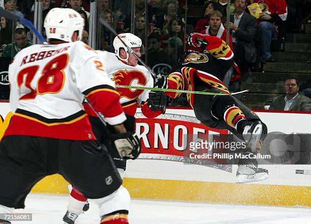Robyn Regehr looks on as Dion Phaneuf of the Calgary Flames lays a huge hit on Denis Hamel of the Ottawa Senators in a game on October 12, 2006 at...