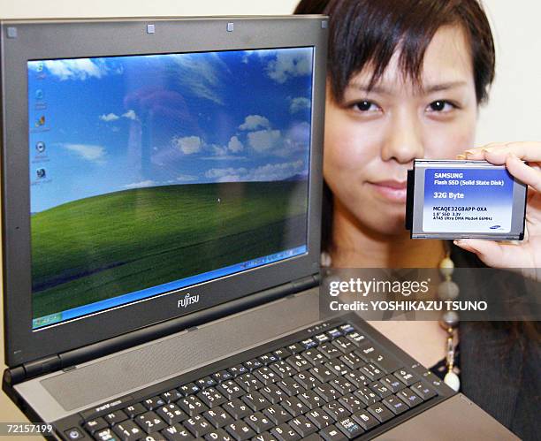 Japan's computer giant Fujitsu employee Miho Hirasawa displays the company's new notebook PC "FMV-Lifebook FMV-Q8230", equipped with Intel's 1.2 GHz...