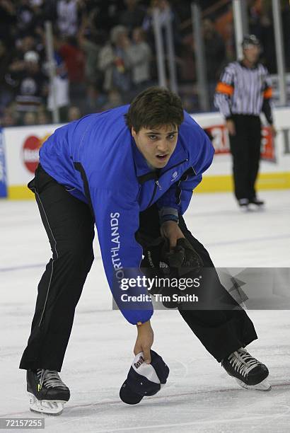 An ice-cleaner collects a hat off of the ice after Ryan Smyth of the Edmonton Oilers scored a hat trick in the third period of their match against...