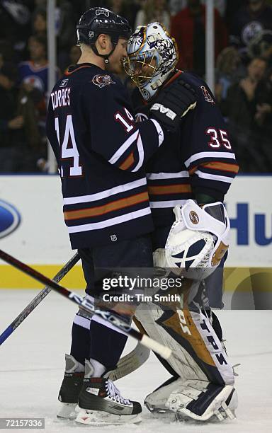 Raffi Torres of the Edmonton Oilers congratulates Oilers goalie Dwayne Roloson after the Oilers 6-4 victory over the San Jose Sharks at Rexall Place...