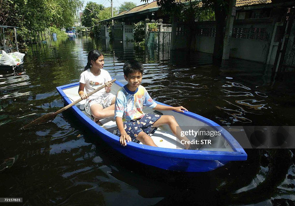 Residents paddles through a flooded vill