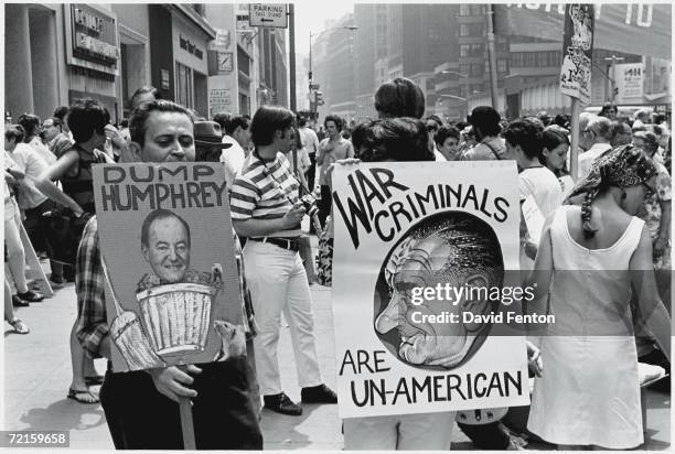 Protestors hold signs at an anti-war rally in New York, New York, Fall 1968. The visible signs read 'Dump Humphrey,' which shows a photograph...