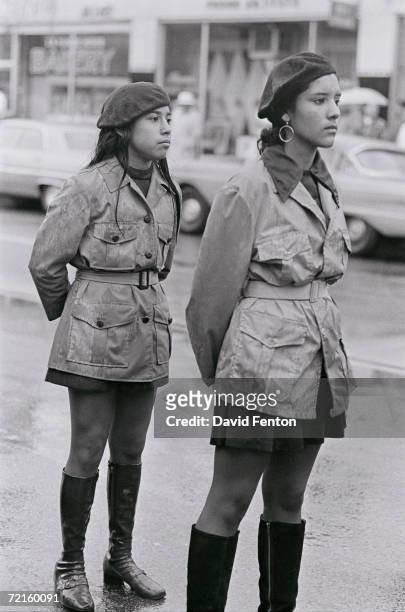 Two female Brown Berets, a Chicano activist group, stand together in matching uniforms during a National Chicano Moratorium Committee march in...