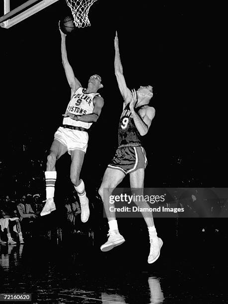 Mel Hutchins, of the Fort Wayne Zollner Pistons, drives for a layup as Bob Pettit, of the St. Louis Hawks, tries to block the shot during a Western...