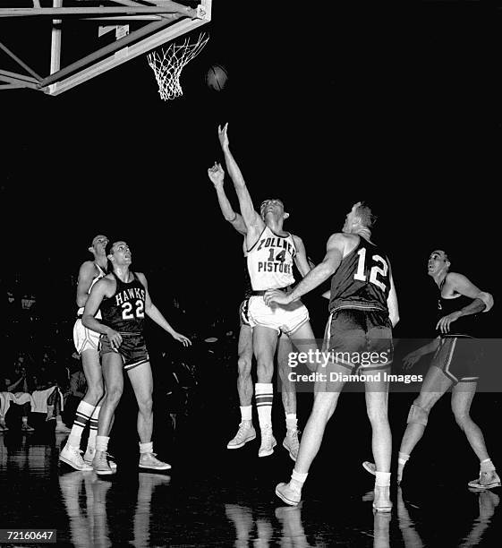 Andy Phillip, of the Fort Wayne Zollner Pistons, tries to score as Al Ferrari and Jack Coleman, of the St. Louis Hawks, wait for any rebound during a...