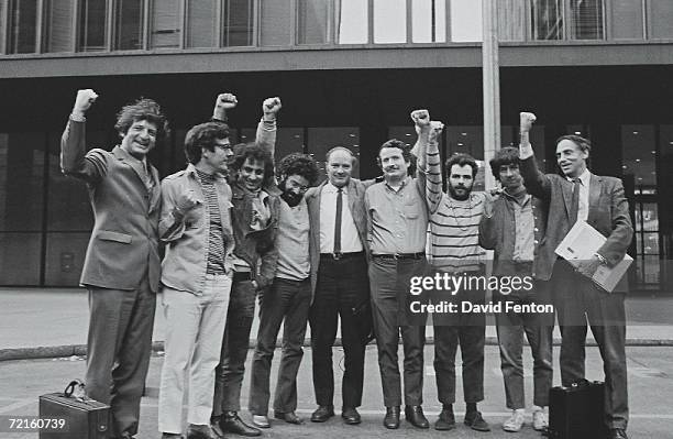 Portrait of the Chicago Seven and their lawyers as they raise their fists in unison outside the courthouse where they were on trial for conspiracy...