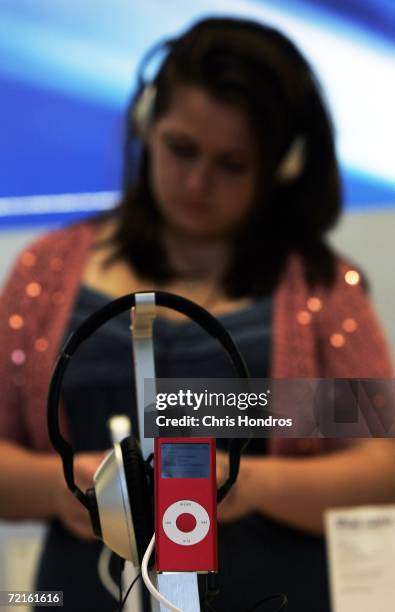 Woman looks at RED iPod nano in the Apple store in midtown Manhattan October 13, 2006 in New York. Apple computer is donating $10 from the sale of...