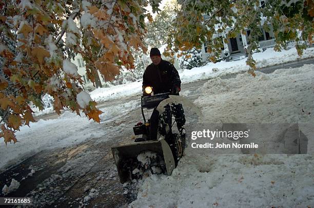Mike Santaro clears snow October 13, 2006 outside of Buffalo in Orchard Park, New York. A rare and record breaking early season snowfall closed a 105...