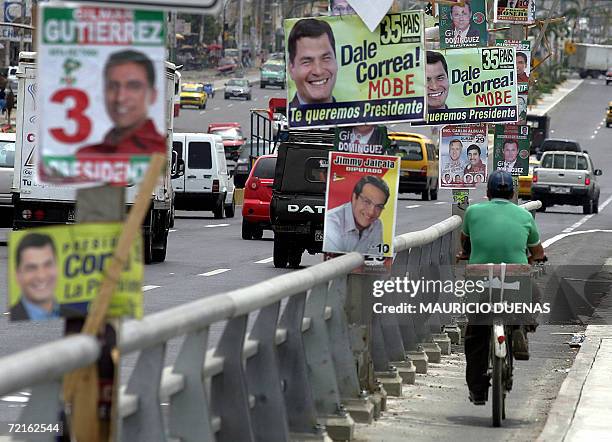 Man rides a bicycle in Guayaquil, Ecuador, where electoral propaganda is seen everywhere 13 October, 2006. Leftist Rafael Correa led the polls but...