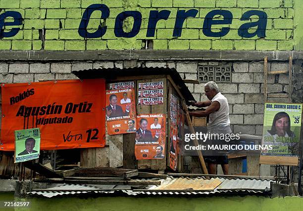 Man covers his house with political posters 13 October in the town of Recreo, Guayas Province, Ecuador, 13 October, 2006. Leftist Rafael Correa led...