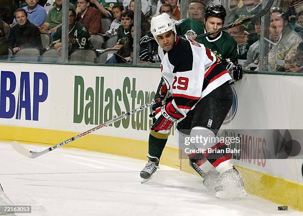 Johnny Oduya of the New Jersey Devils battles for the puck during a game against the Dallas Stars at American Airlines Center on October 7, 2006 in...