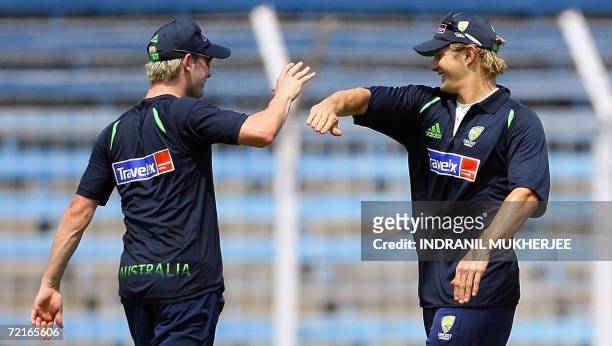 Australian cricketer Michael Clarke is congratulated by teammate Shane Watson for a run out during a training session in Mumbai, 14 October 2006....