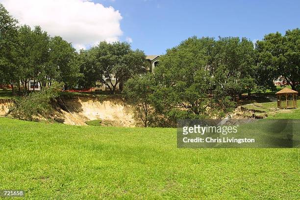 Sinkhole measuring 150 feet wide and about 60 feet deep is shown June 12, 2002 a day after it opened near the Woodhill Apartments in Orlando,...
