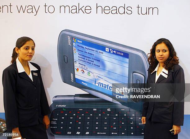 Indian models pose with a newly launched I-Mate, the specialist in Microsoft Windows Mobile devices and software applications, the world's first...
