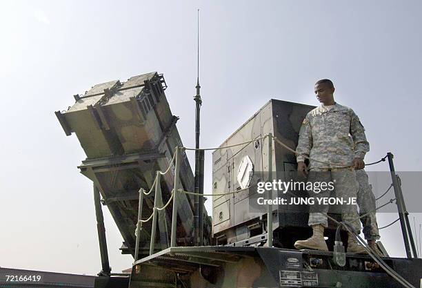 Osan, REPUBLIC OF KOREA: An US soldier stands on the launcher of a Patriot missile PAC-3 system during Air Power Day at the US airbase in Osan, south...