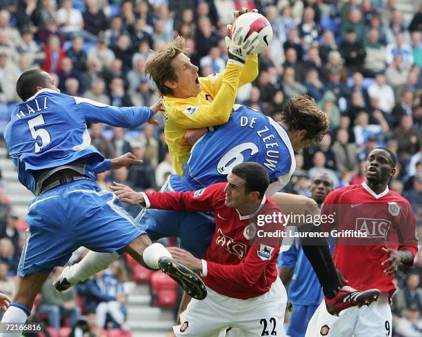 Edwin Van Der Sar of Manchester United collects the ball in front of John O'Shea under pressure from Fitz Hall and Arjan De Zeeuw of Wigan during the...