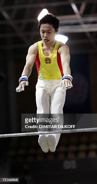 China's Kai Zou performs on the horizontal bar during the men's qualifiers at the 39th Artisitic Gymnastics World Championships 14 October 2006, at...