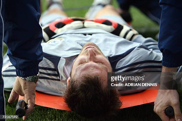 Reading, UNITED KINGDOM: Chelsea goalkeeper Petr Cech lies is evacuated after being injured in the first few minutes of the game against Reading...