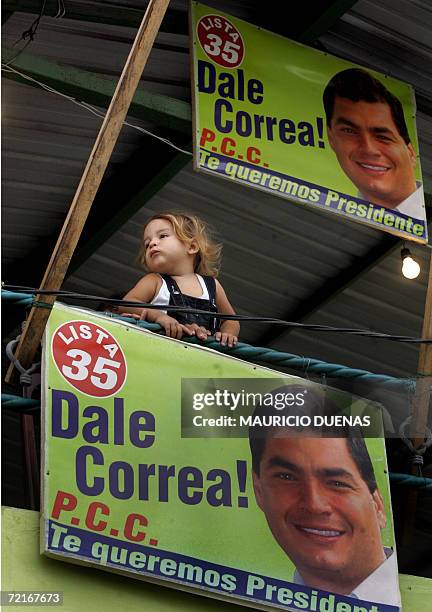 Little girl plays next to propaganda of presidential candidate Rafael Correa 14 October in the town of Recreo, Guayas province, Ecuador. Leftist US...