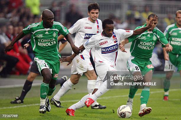 Lyon's French forward Sidney Govou vies with Saint-Etienne's Congolese defender Herita Ilunga and Saint-Etienne's Brazilian forward Araujo Ilan...
