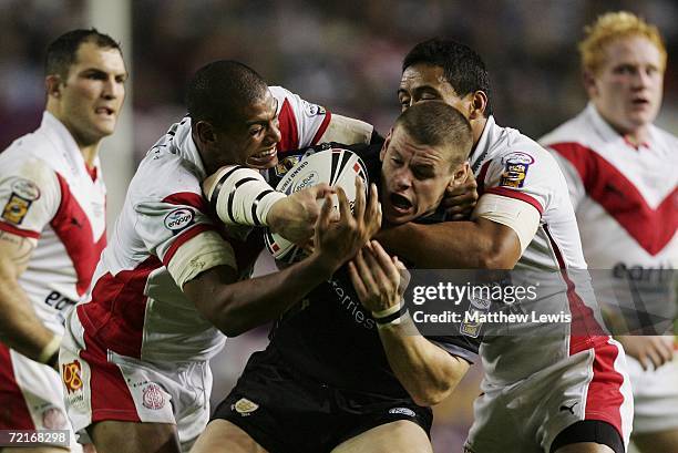 Lee Radford of Hull FC is wrapped up by Leon Pryce and Willie Talau of St. Helens during the Engage Super League Grand Final between St. Helens and...