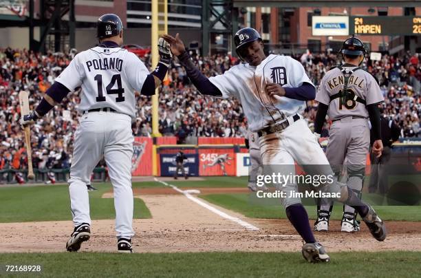 Curtis Granderson of the Detroit Tigers celebrates with teammate Placido Polanco after Granderson scored on a Craig Monroe double in the bottom of...