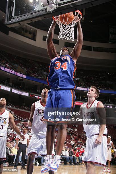 Eddy Curry of the New York Knicks slam-dunks against Steven Hunter and Shavlik Randolph of the Philadelphia 76ers on October 14, 2006 at the Wachovia...