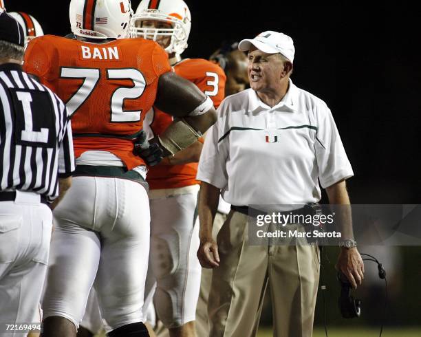 University of Miami Hurricanes head coach Larry Coker chats with guard Andrew Bain during his teams game against Florida International University...
