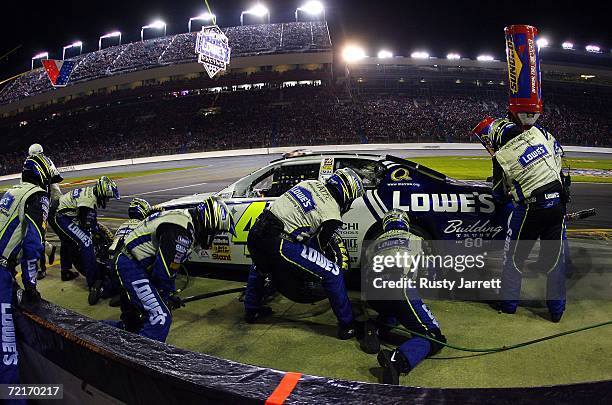 Crew members for Jimmie Johnson, driver of the Lowe's Chevrolet, work on the car during a pit stop, during the NASCAR Nextel Cup Series Bank of...