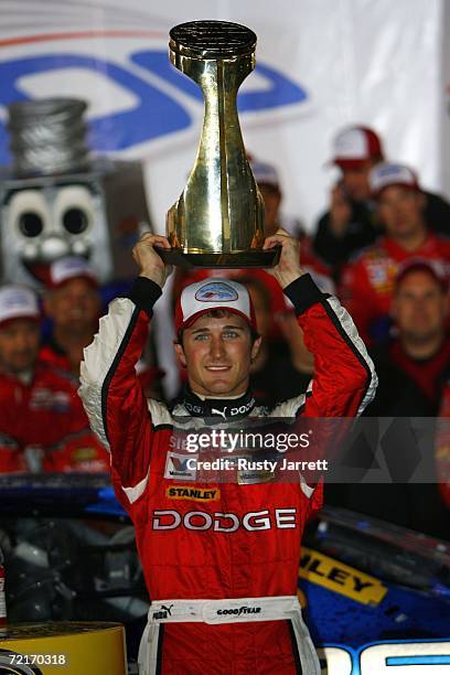 Kasey Kahne, driver of the Dodge Dealers/UAW Dodge, holds the winners trophy in victory lane after winning the NASCAR Nextel Cup Series Bank of...