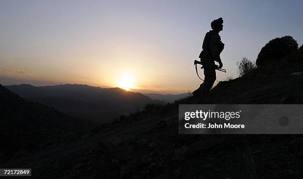 Army soldier climbs a hill towards an American outpost October 15, 2006 near Camp Tillman, Afghanistan just two kilometers from the Pakistan border....