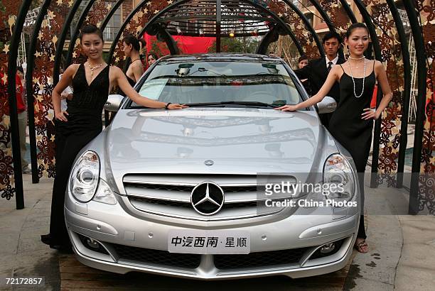 Models pose with a Mercedes-Benz R350 car during a promotion for property owners in a wealthy residential district October 14, 2006 in Chongqing...