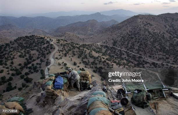 Army soldier checks the sights of machine gun atop an American outpost October 15, 2006 near Camp Tillman, Afghanistan just two kilometers from the...