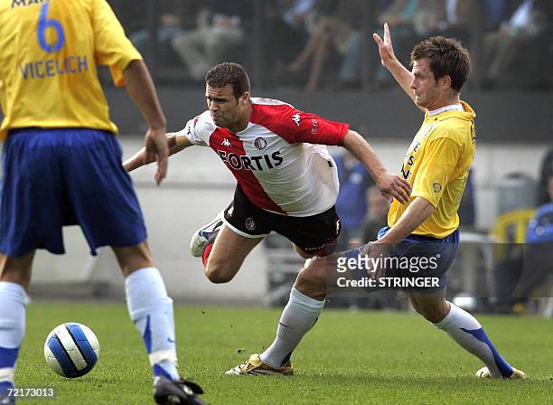 Waalwijk, NETHERLANDS: Feyenoord's Ali Boussaboun falls over the knee of Waalwijk 's Stephan Keller , 15 October 2006 in Netherlands ' L1 match...