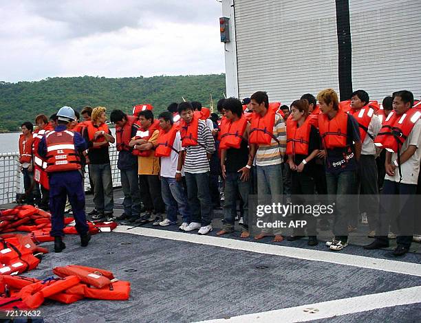 Puntarenas, COSTA RICA: Costo Rican and US migratory authorities take care, 14 October 2006, in Puntarenas, Costa Rica, of 70 Chinese and 58...