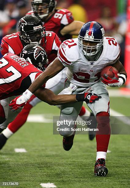 Tiki Barber of the New York Giants runs past Jason Webster of the Atlanta Falcons in the second half on October 15, 2006 at the Georgia Dome in...