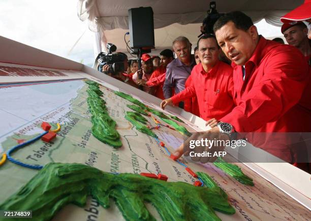 El presidente venezolano Hugo Chavez examina, el 15 de octubre de 2006, en Caracas, el modelo de las vias ferreas que irian desde la capital a la...