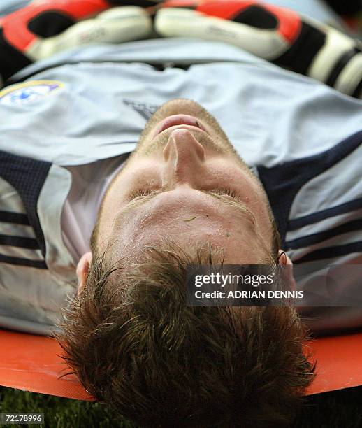 Reading, UNITED KINGDOM: - Chelsea's goalkeeper Petr Cech lies injured after an early tackle during the Premiership football match at Madejski...