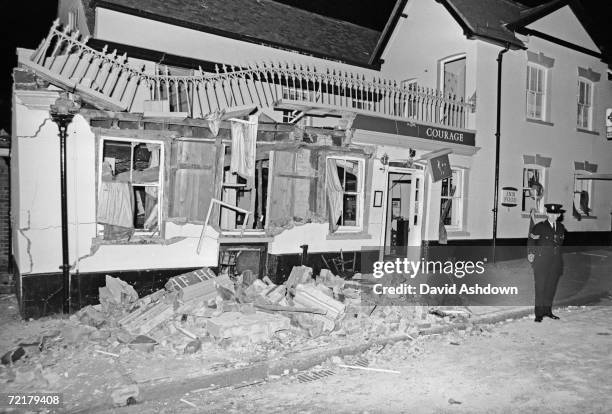 Policeman stands guard outside the Horse and Groom pub in Guildford, Surrey, wrecked after an IRA bomb explosion which killed five people and injured...