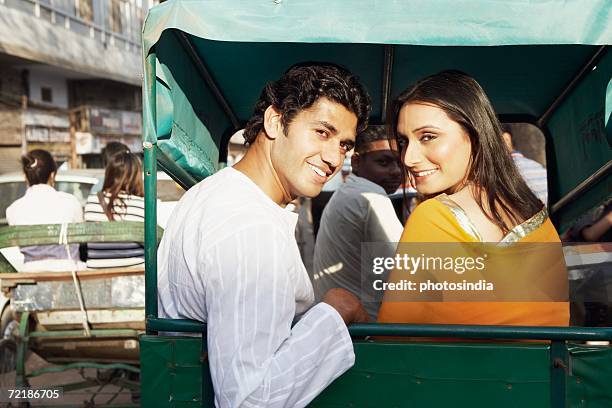 portrait of a young couple sitting in a rickshaw and smiling - pedicab stock pictures, royalty-free photos & images